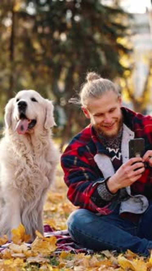 Funny Content Young Positive Bearded Guy Taking Selfie with His Dog on Smartphone During Walk in