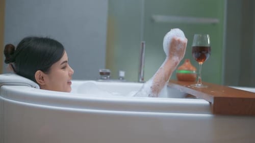 Woman Relaxing in a Bubble Bath with Wine
