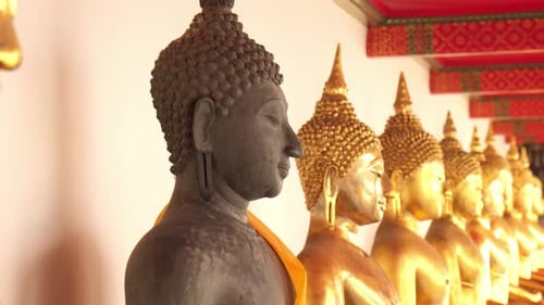 Multiple Buddha images in line at Wat Pho temple in Bangkok, Thailand