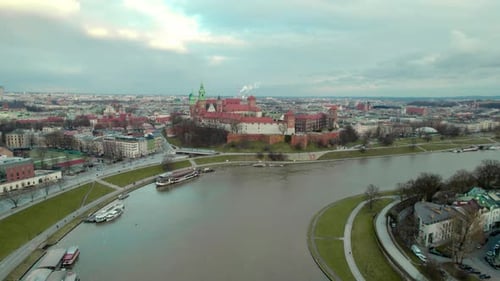 Forward dolly shot over Vistula river and Krakow Wawel Royal Castle, city center fortress with the o