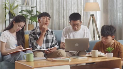 Young Adults Studying Together on Couch at Home
