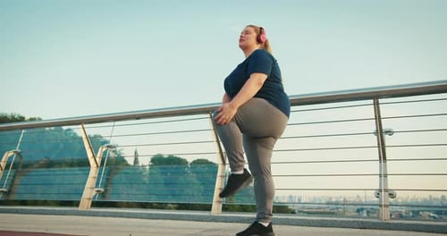 Woman Stretching on Bridge in Urban Setting