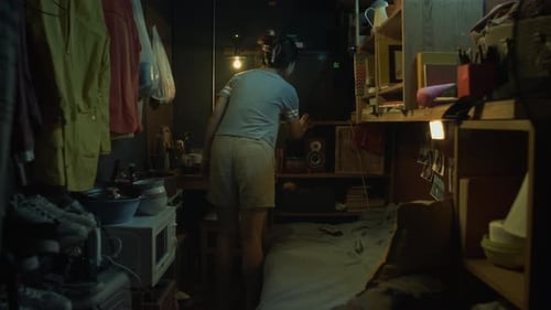 Young Chinese Woman Lying Down to Watch TV in Tiny Apartment