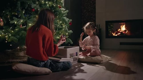 Woman and Child Decorating Christmas Tree at Home
