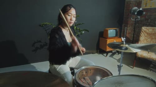 Cool Female Musician Drumming with Feel on Drum Kit in Studio