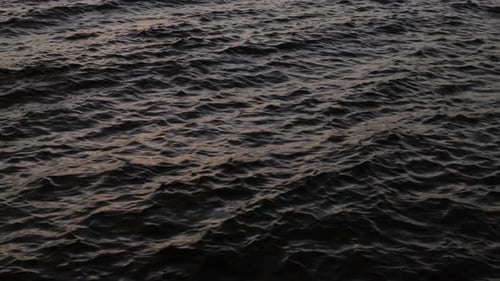 Zeitlupe einer wellenförmigen Meereslandschaft bei Sonnenuntergang.