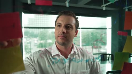 Professioneller männlicher Leiter, der Marketingideen auf Haftnotizen schreibt. Manipulator
.