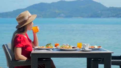 Woman Enjoy Beautiful and Healthy Breakfast at Luxury Hotel By the Sea in Tropics