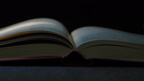 Hand Turns Page in Open Book