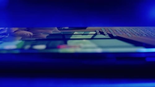 Nahaufnahme von Händen eines jungen Mannes, der nachts süchtig auf TikTok in den sozialen Medien scrollt. Smart P mit dem Finger scrollend