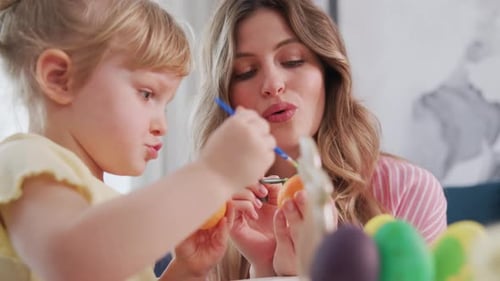 Young Girl and Mother Decorate Eggs for Easter