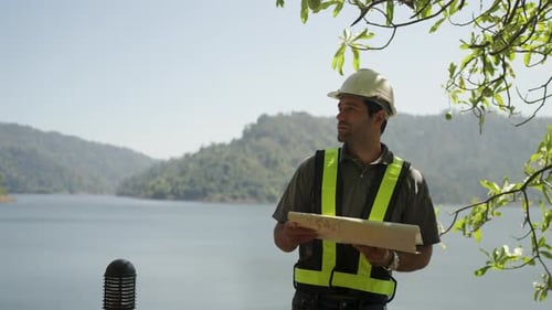 Blue collar worker is working at the dam.