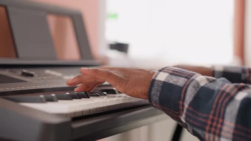 Hands Playing Electronic Keyboard in Bright Home
