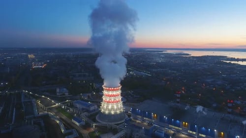 Upper View Brightly Lit Cooling Tower Against City and Lake