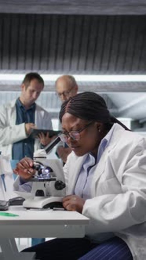 Vertical Video African American Scientist Placing Tray Under the Microscope