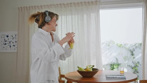 Woman Dances and Sings in Kitchen with Banana