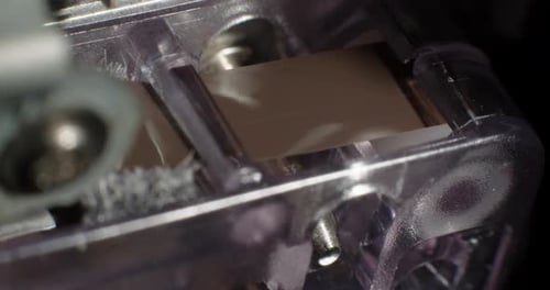 Extreme Close-Up Of Microcassette Recorder Tape Ribbon Running Through Cassette