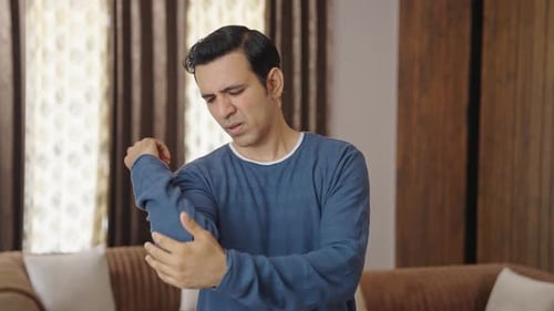 Middle aged Indian man suffering from hand and arm pain