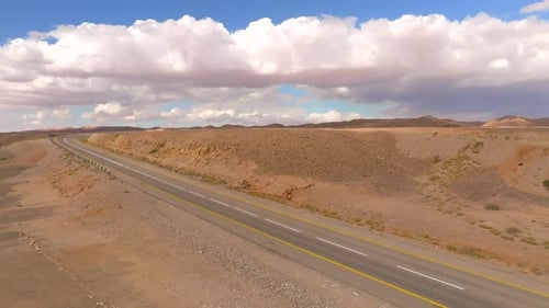 Empty Desert highway mountain road with Blue cloudy sky