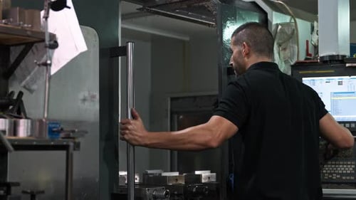 Man Operating Industrial Machinery in Factory Workplace