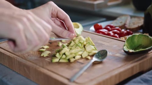 Hands Dicing Avocado on Wood Cutting Board