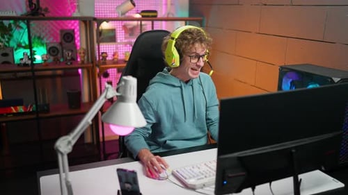 Excited Young Adult Playing Video Game at Desk