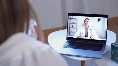 Woman Has Telehealth Appointment With Smiling Doctor