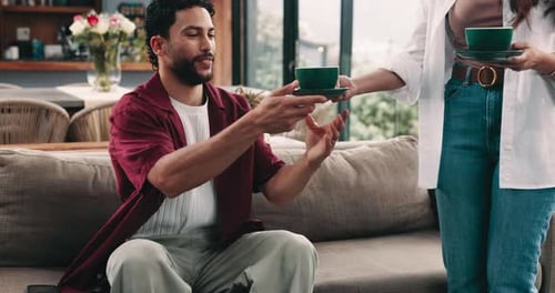 Couple Drinking Coffee and Conversing in Living Room