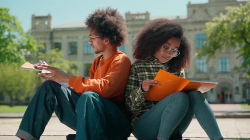 Two African American Students Reading Textbooks Studying Outdoors University Friends Couple Woman