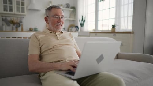 Senior Man Using Laptop Computer at Home