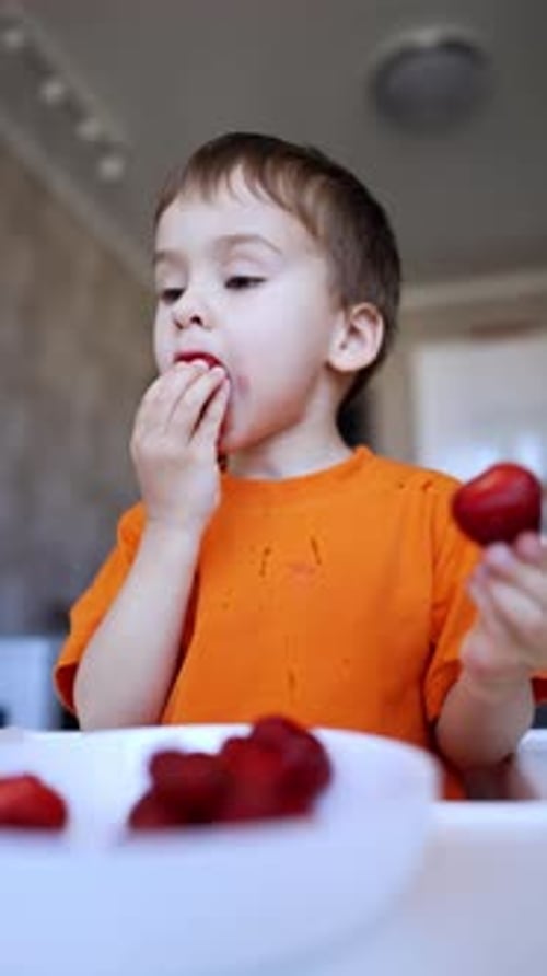 Boy Enjoys Eating Sliced Red Strawberries