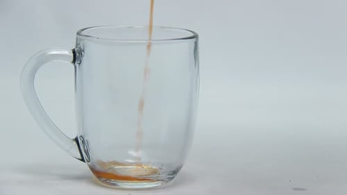 Red Liquid being poured into clear glass mug