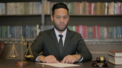 Adult in Suit Behind Desk with Legal Paraphernalia