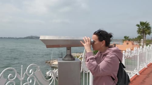 Uma mulher olha através de binóculos