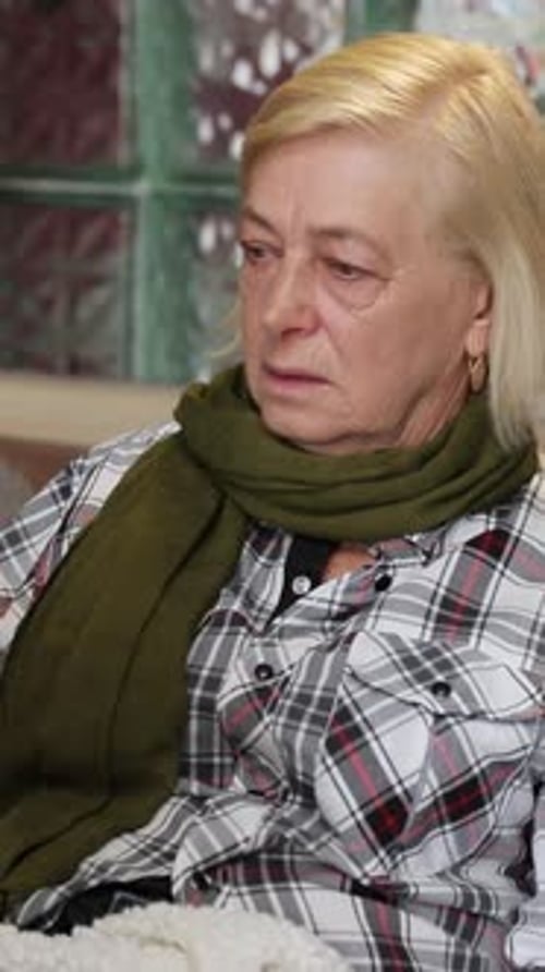 Senior Woman Sitting on Couch Sick with Laptop
