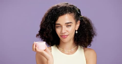 Attractive Woman Holding Beauty Product in Studio Setting