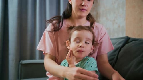 Woman and child sit together on couch indoors