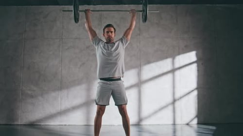 Powerful Man Lifting Barbell in Sport Club Bodybuilder Training Weight Exercise