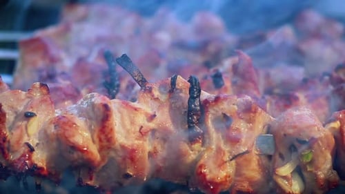 Fleisch, das im Freien auf Holzkohle gegrillt wird. Nahaufnahme. Rauch über heißem Shish Kebab
