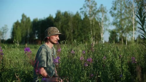 Young Man is Meditating While Sitting Amidst Plants in Forest