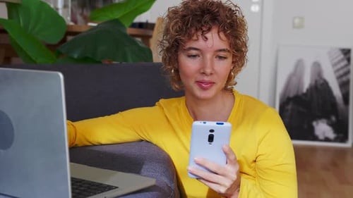 Young Woman Using Laptop and Mobile Phone Indoors