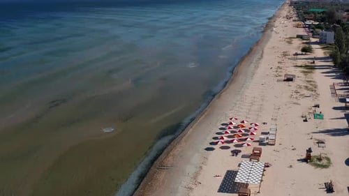 Beautiful flight in summer over the beach. People are resting near the sea. Houses for tourists.