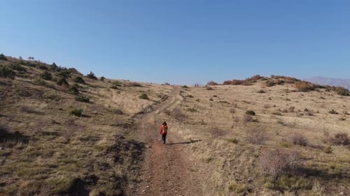 Aerial View Young hiker walking on a mountain path on a sunny day