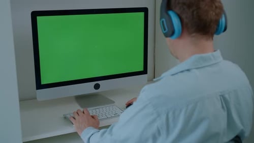 Adult Working at Desktop Computer with Green Screen
