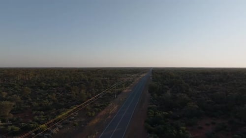 Clip de un dron que muestra una larga carretera recta a través del desierto del interior de Australia hacia el horizonte