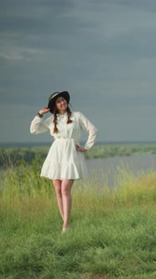 Young Woman in White Dress Standing in Field