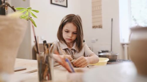 Child Creating Pottery in a Bright Studio Setting
