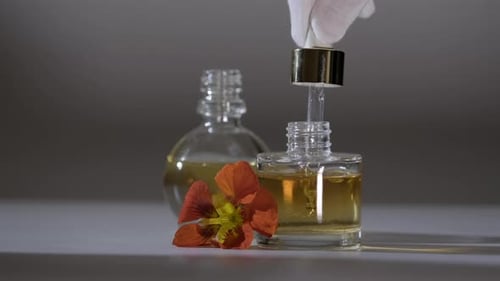 Produto de óleo essencial. Perfumaria. Gotas caindo da pipeta cosmética para o frasco de vidro com perfume