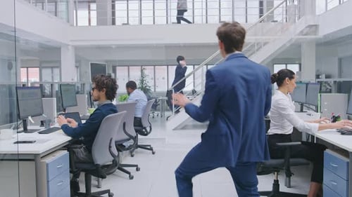 Jeune et beau directeur d'entreprise joyeux portant un costume et une cravate dansant au bureau. Diversifié et