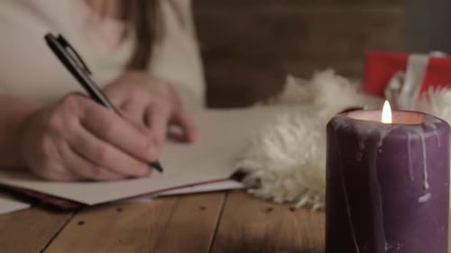 Woman Writes Christmas Card by Candlelight